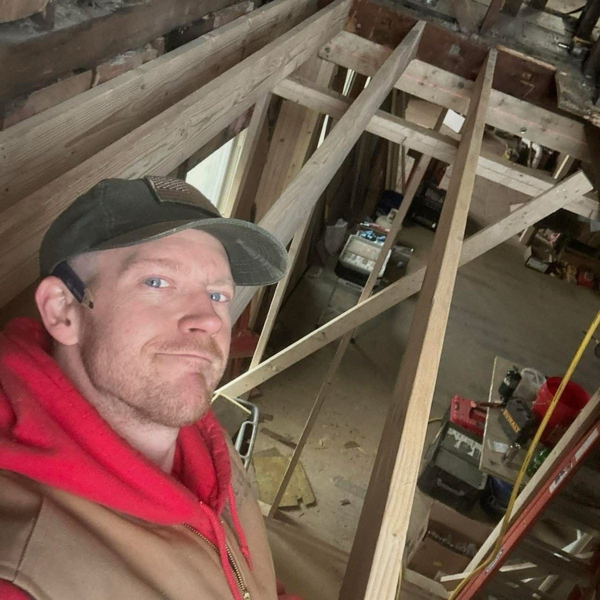 Zack working among timber framing during a home renovation